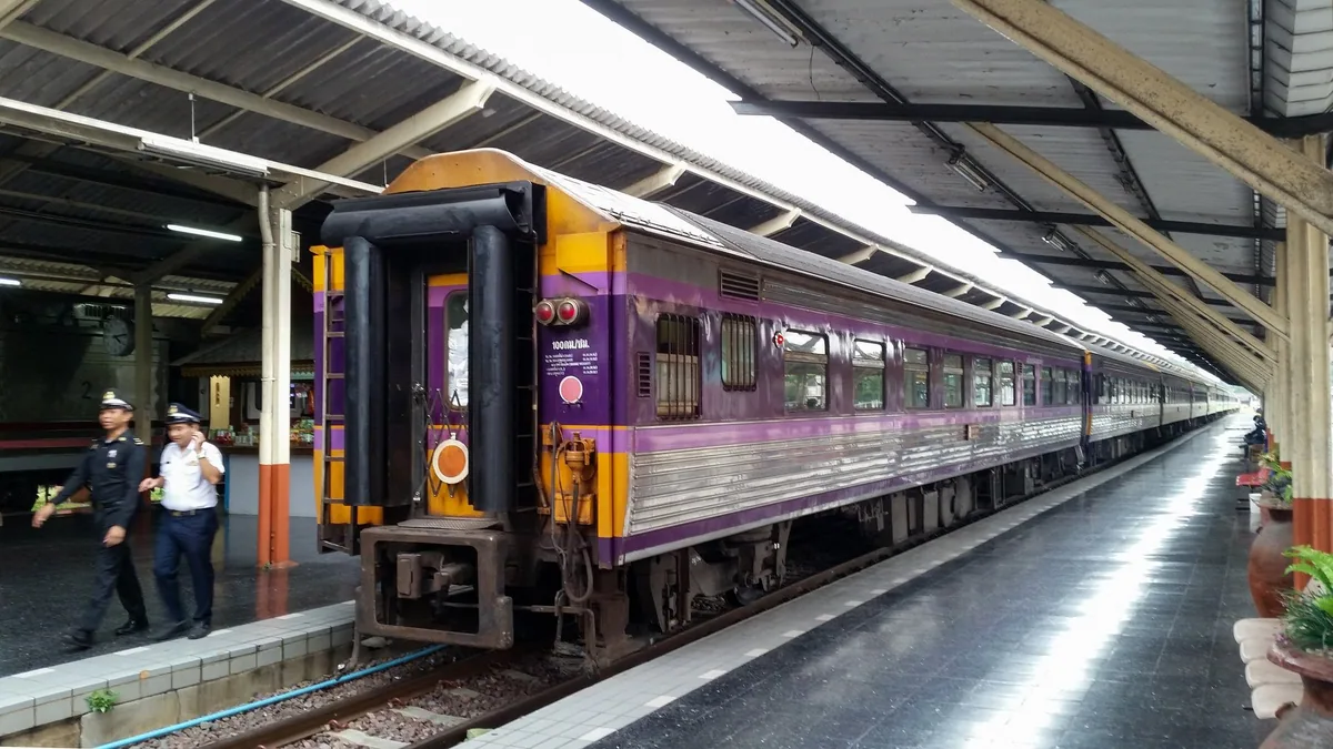 Purple-and-silver sleeper train carriage waiting at the platform of Chiang Mai railway station