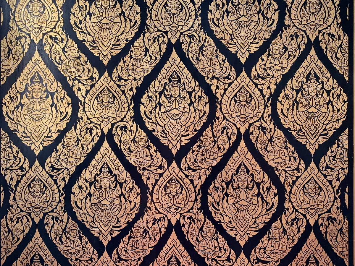Gold lacquer temple pattern of thep phanom deities with palms pressed together in a wai, Wat Thepthidaram