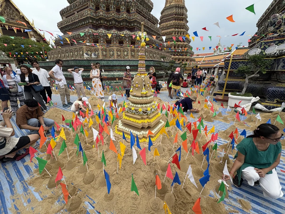 Sand stupas decorated with colourful paper flags in the courtyard of Wat Pho in Bangkok during Songkran