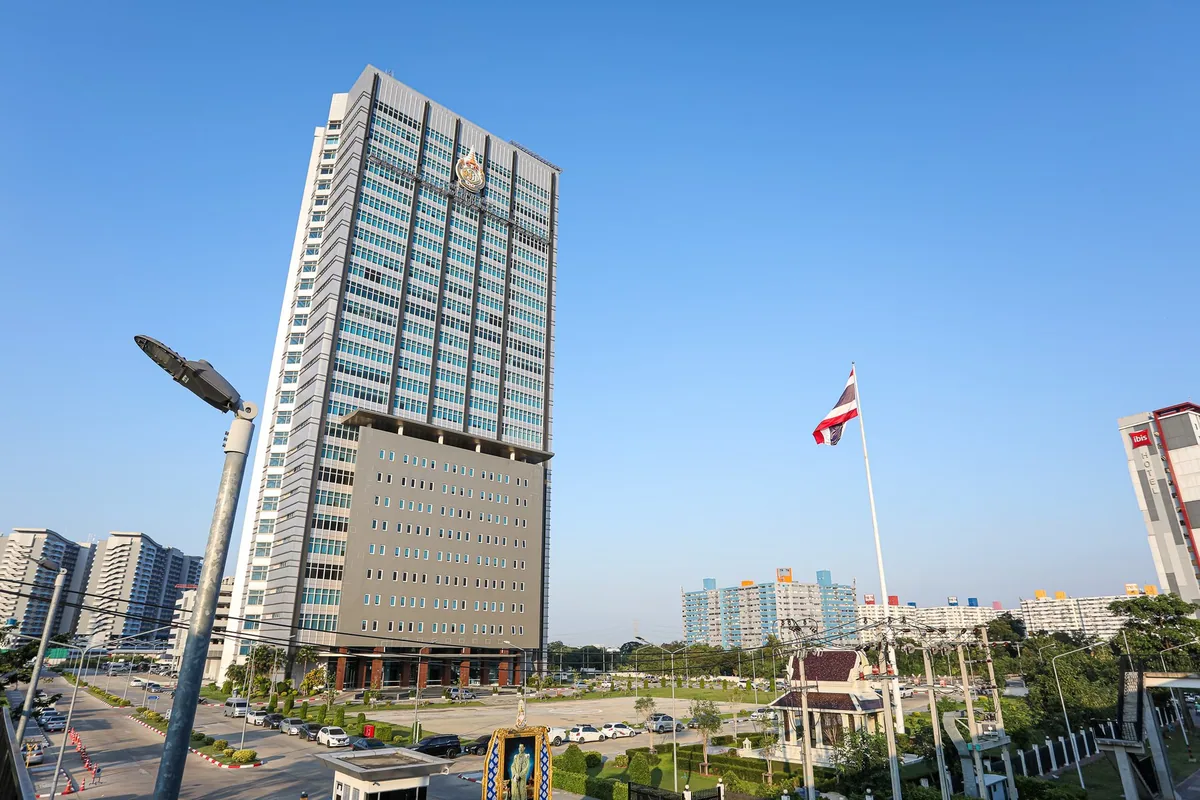 The Immigration Bureau headquarters of the Royal Thai Police in Bangkok, with the Thai flag in front