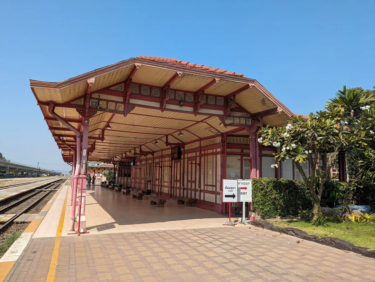 Red and cream wooden platform building at Hua Hin railway station beside the tracks