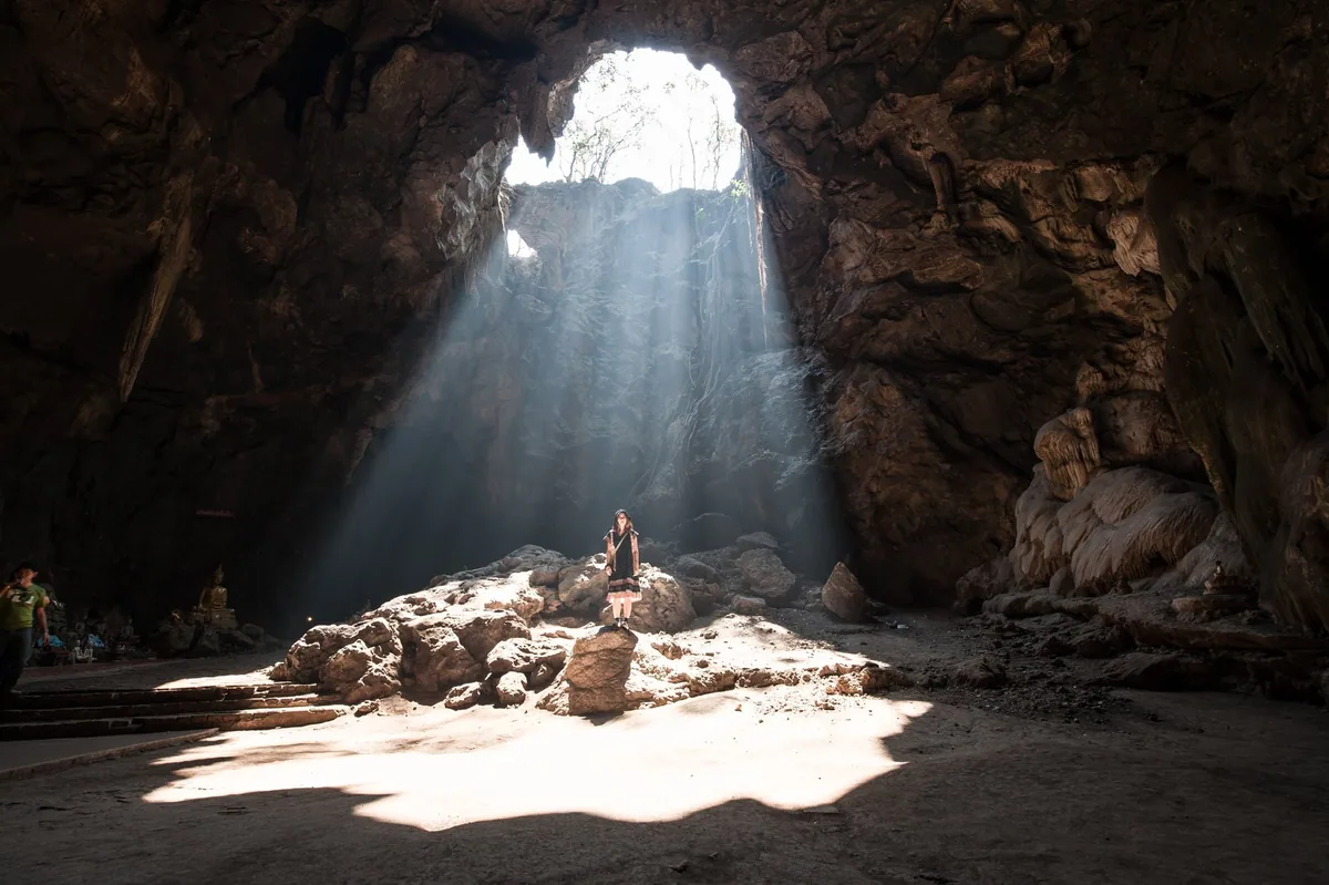 Shafts of sunlight falling through the roof opening into Khao Luang Cave near Phetchaburi