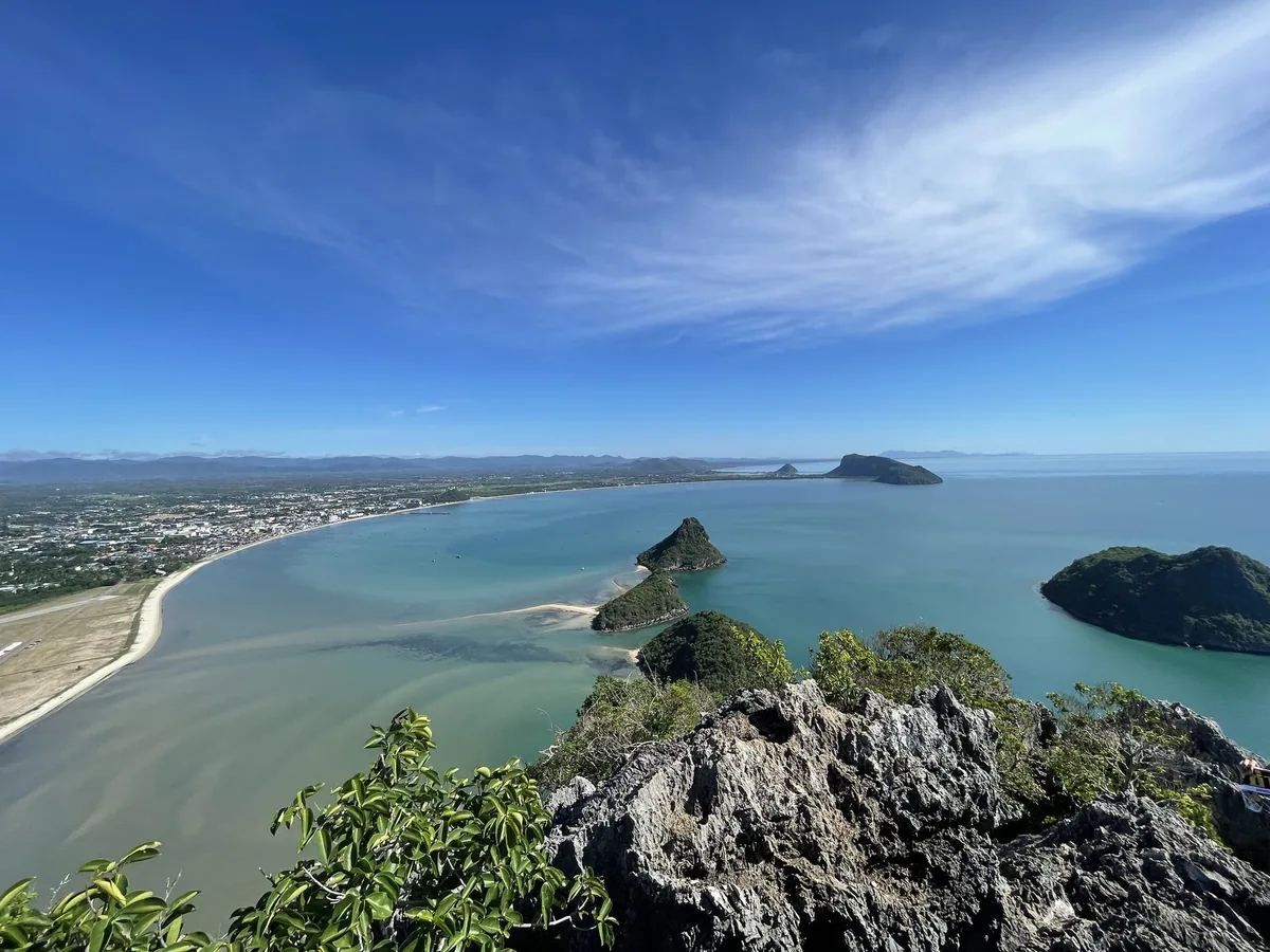 Prachuap Bay curving past limestone islets toward the town, seen from the rocky summit of Khao Lom Muak at Ao Manao