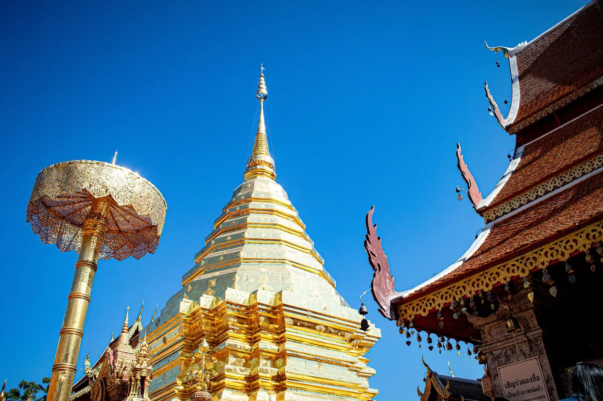 Golden chedi and ceremonial parasol of Wat Phra That Doi Suthep against a deep blue sky