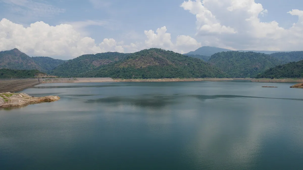 Forested hills around the calm reservoir behind Khun Dan Prakan Chon Dam in Nakhon Nayok