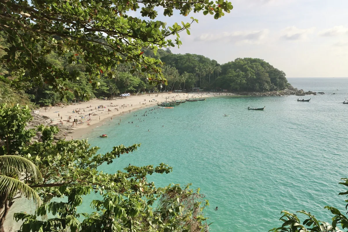 Turquoise water and white sand of Freedom Beach on Phuket's west coast framed by jungle