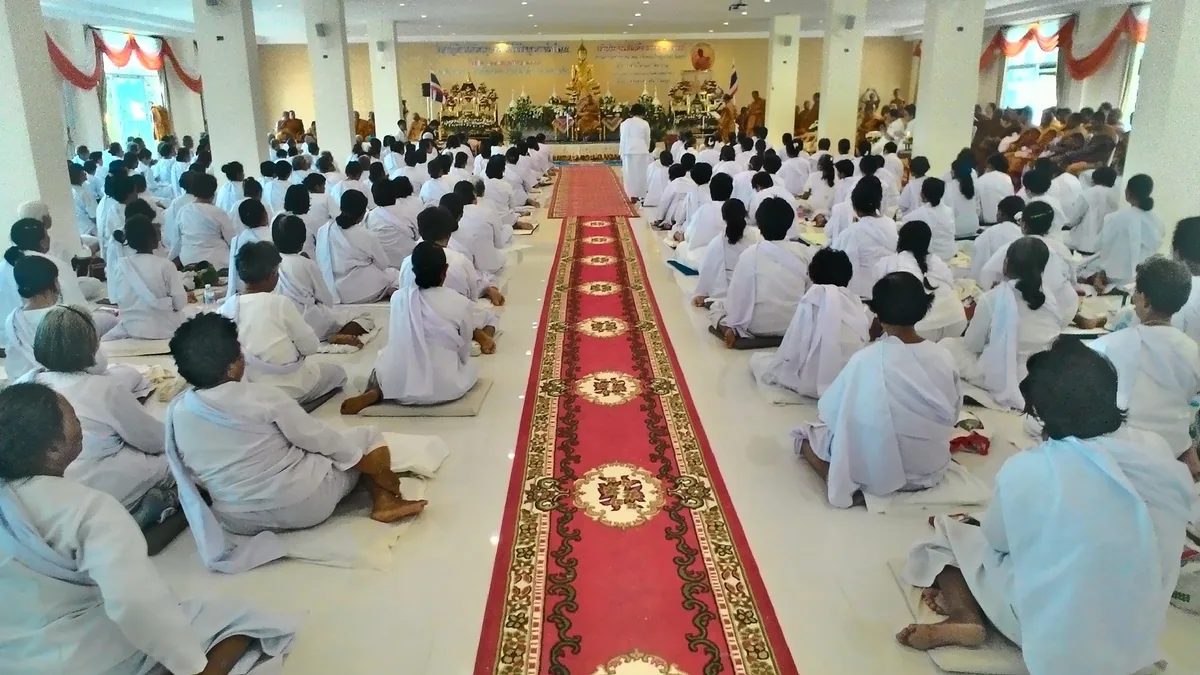 Lay Buddhists dressed in white sit in rows for prayers on Visakha Bucha Day at Wat Pa Pavanaram