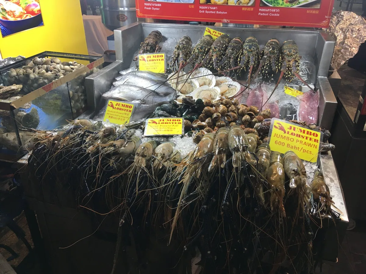Lobsters, giant river prawns, scallops and fish on ice at a Bangkok Chinatown stall, priced per piece and by weight