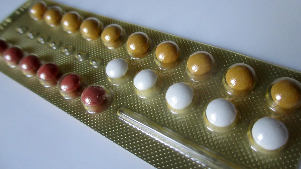 Close-up of a blister strip of contraceptive pills in several colours