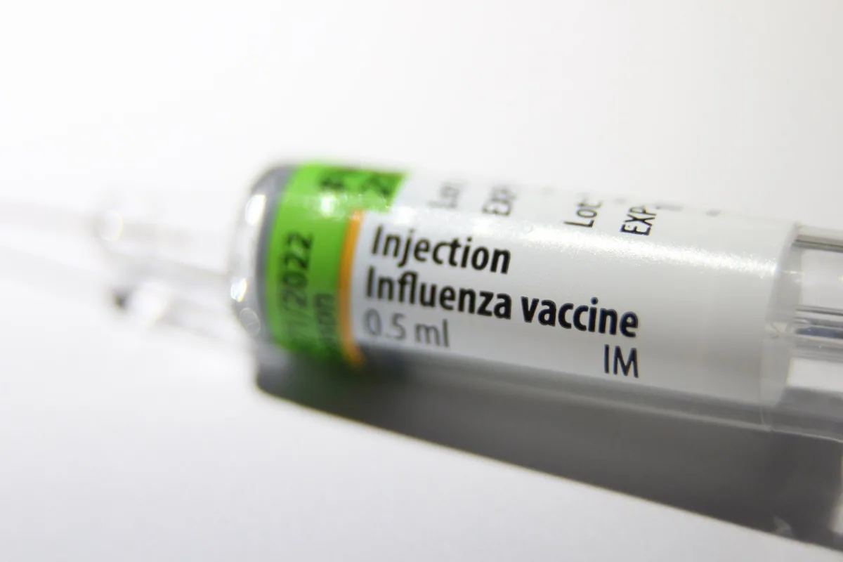 Close-up of a pre-filled 0.5 ml influenza vaccine syringe labelled for intramuscular injection