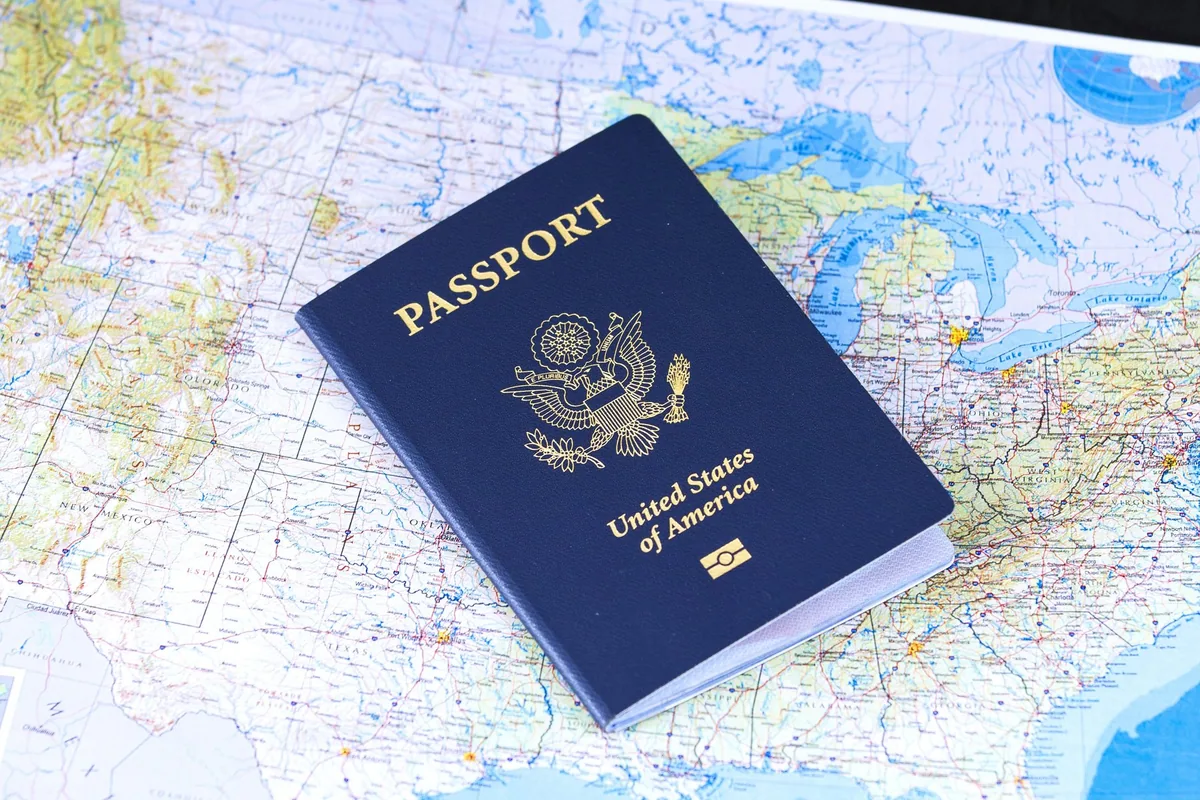 A United States passport lying on a printed world map