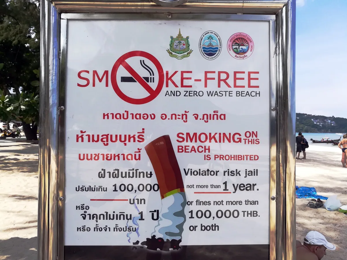 Smoke-free beach sign on Patong Beach, Phuket, warning of fines and jail for smoking on the sand