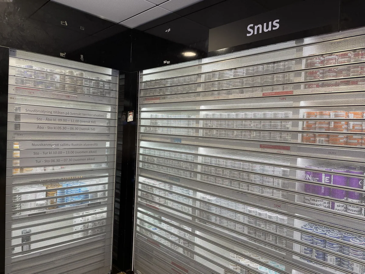 Shelves of snus tins locked behind shutters in a ferry tax-free shop