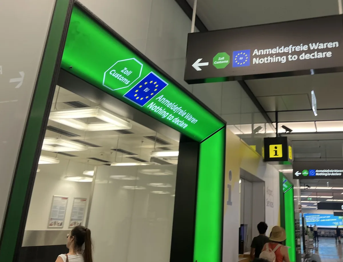 Green 'Nothing to declare' customs lane with EU signs in an airport arrivals hall