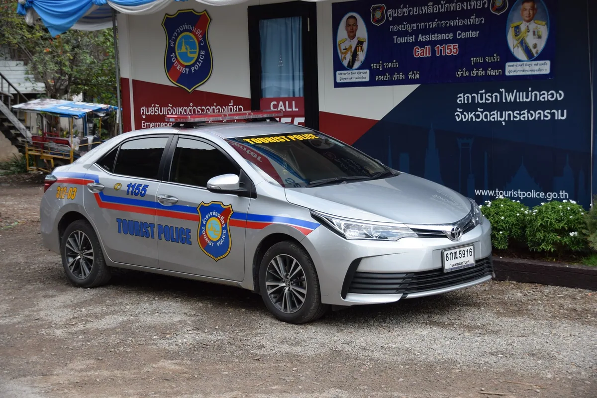 A silver Thai Tourist Police patrol car marked with the 1155 hotline number