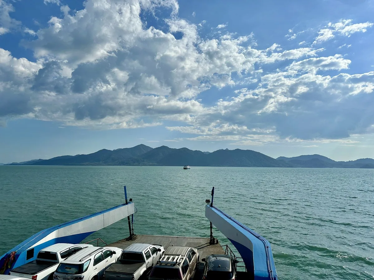Koh Chang's forested mountains seen across calm sea from the deck of the car ferry from the Trat mainland