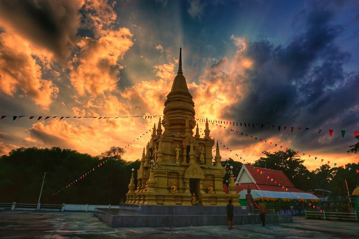 The golden Laem Sor Pagoda on Koh Samui under a fiery sunset sky
