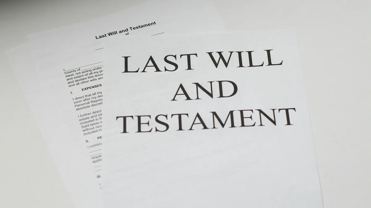 Printed pages of a last will and testament form lying on a white desk