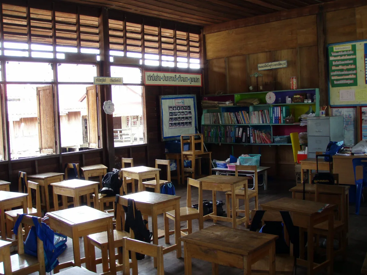 Wooden desks and chairs in an empty classroom at the village school on Koh Panyee, Phang Nga