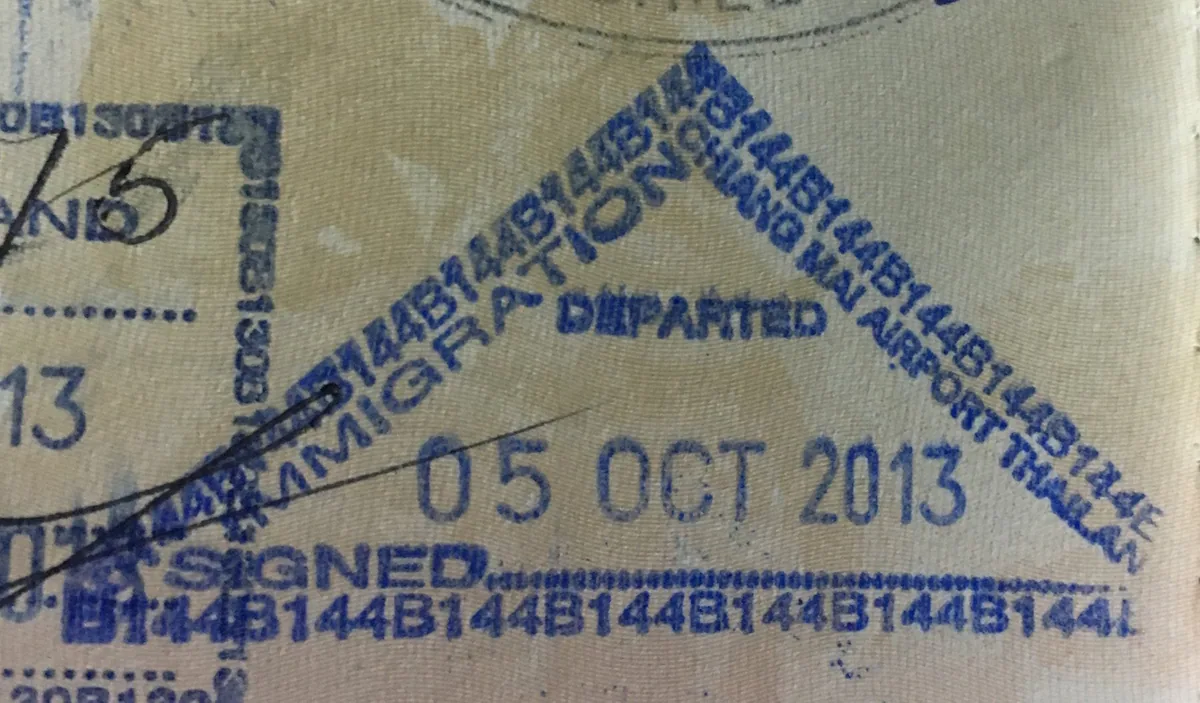 Blue triangular Thai immigration 'Departed' stamp from Chiang Mai Airport in a passport