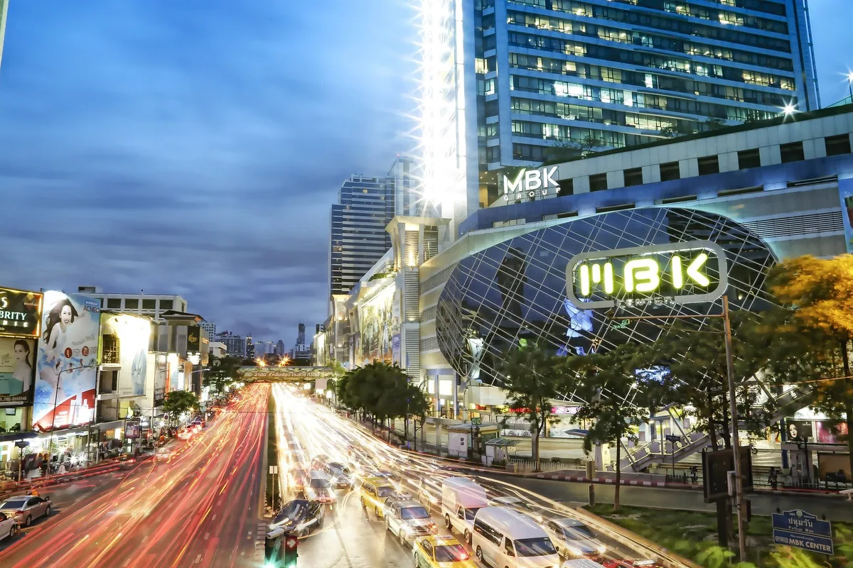 Evening traffic streaming past the MBK Center shopping mall at the Pathum Wan intersection in Bangkok