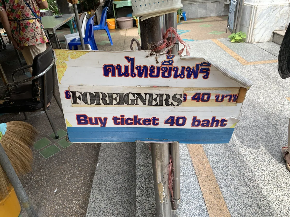 Hand-painted sign at Wat Hua Lamphong in Bangkok: free entry for Thais, foreigners buy a 40-baht ticket