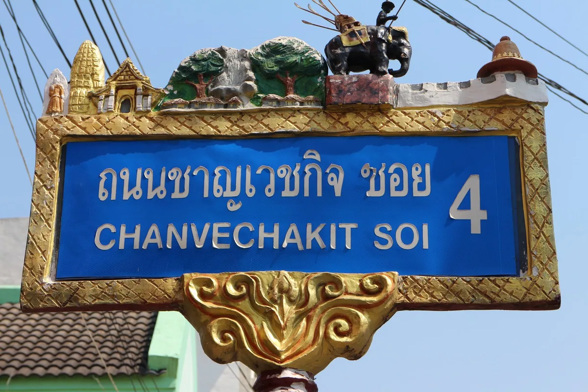 Ornate bilingual street sign in Phitsanulok reading Chanvechakit Soi 4 in Thai and English letters