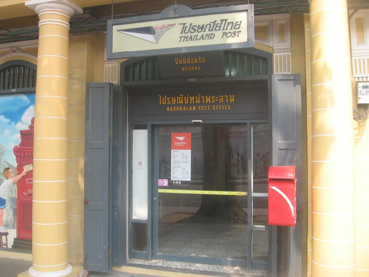 Entrance to the small Naphralan post office in Bangkok, with a red Thailand Post letterbox beside the door