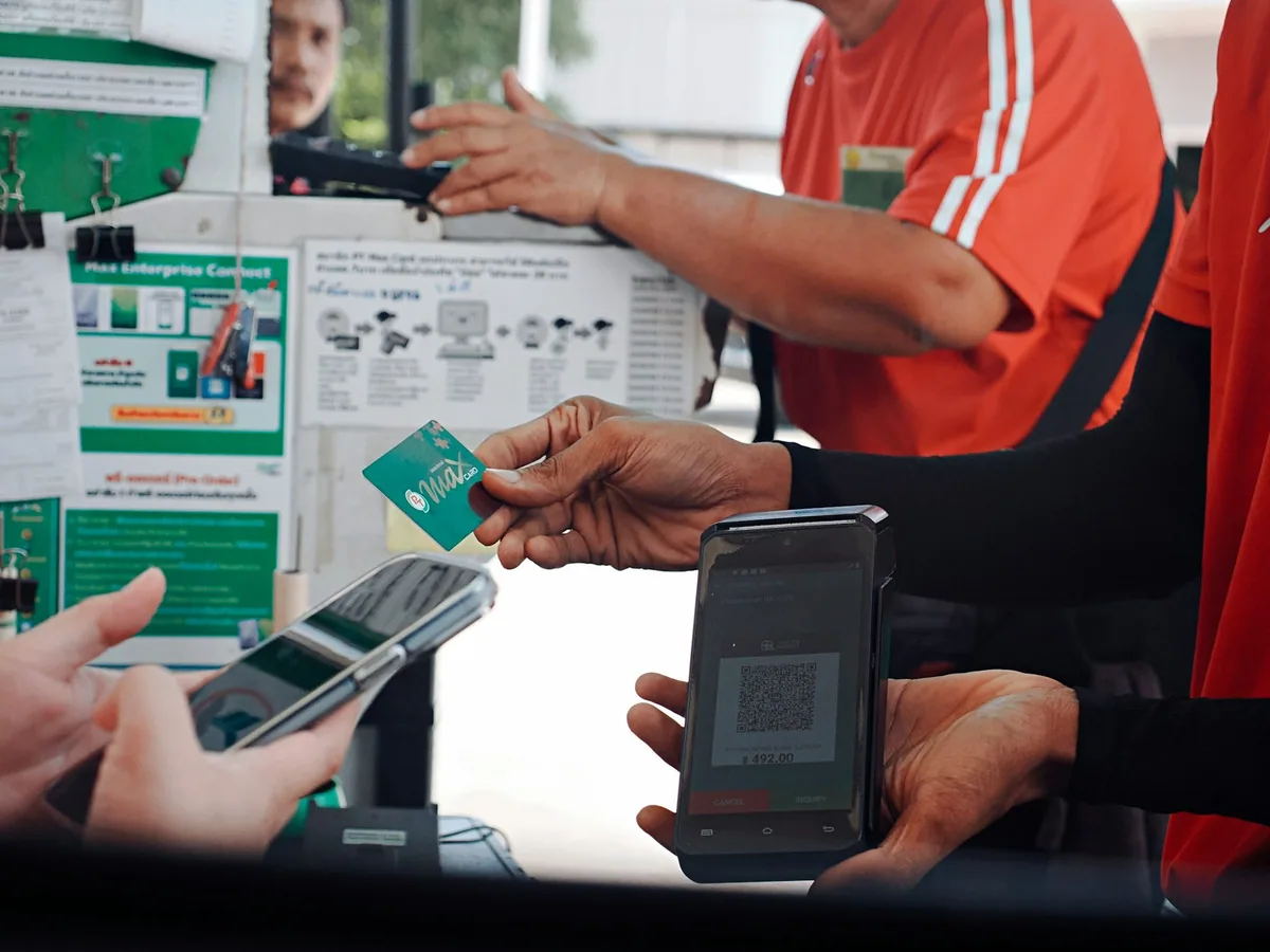 A customer paying with a smartphone at a shop counter