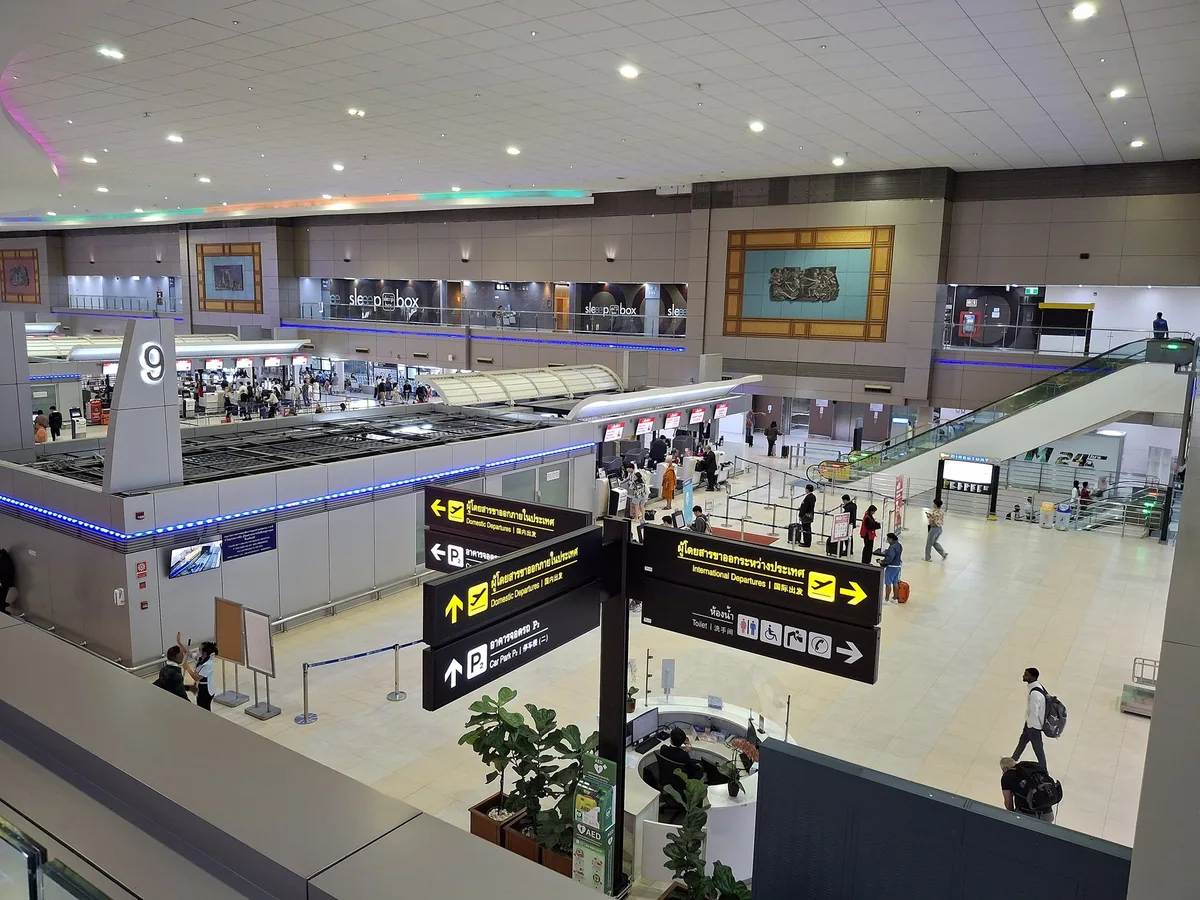Check-in hall and direction signs inside Terminal 2 at Don Mueang Airport, Bangkok