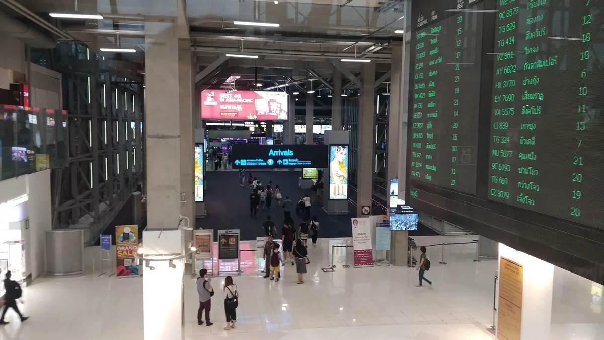 Arrivals hall at Suvarnabhumi Airport with signs leading passengers to the immigration counters