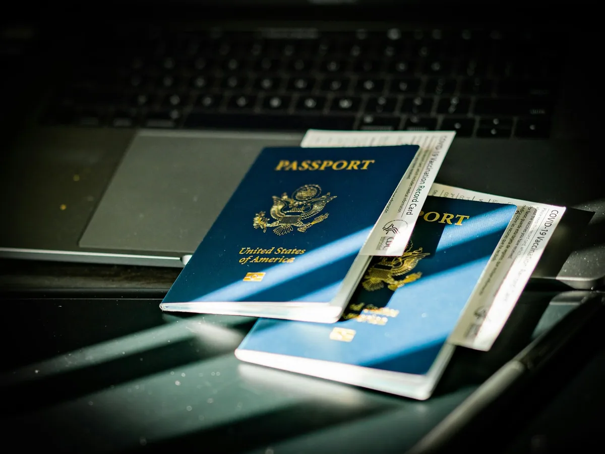 A passport lying on a laptop keyboard, ready for an online visa application