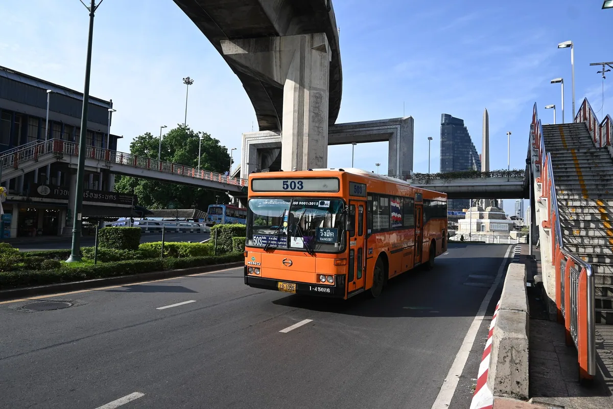 An orange BMTA city bus on route 503 to Rangsit leaving Victory Monument in Bangkok, under an elevated road