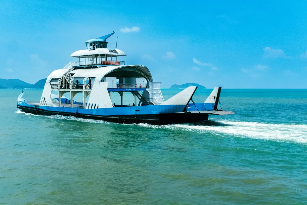 Blue and white car ferry crossing turquoise water on the route to Koh Chang